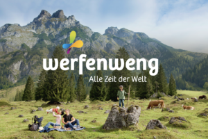 Alpenkulisse mit Familie auf Bergwiese im Vordergrund