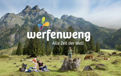 Alpenkulisse mit Familie auf Bergwiese im Vordergrund